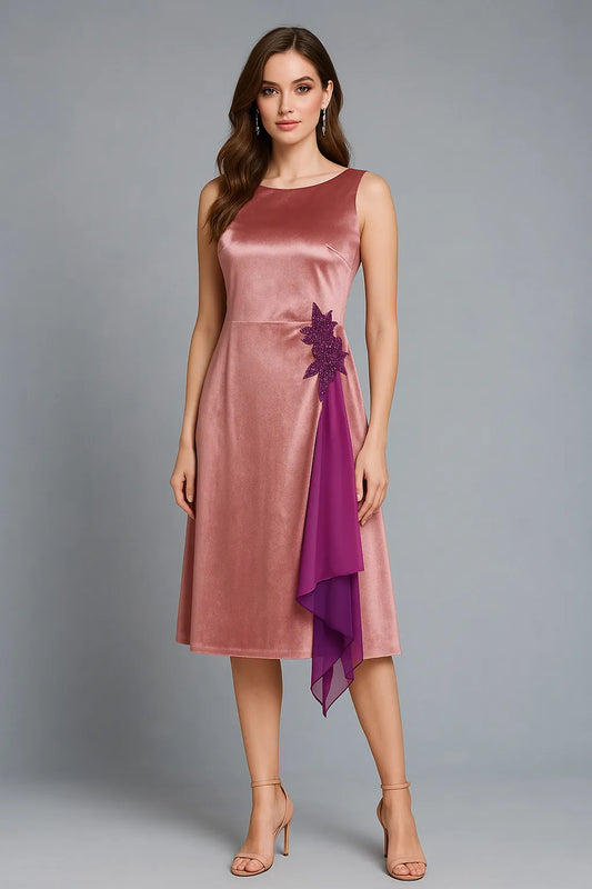 Woman wearing a pink satin tango dress with a purple accent on a gray background