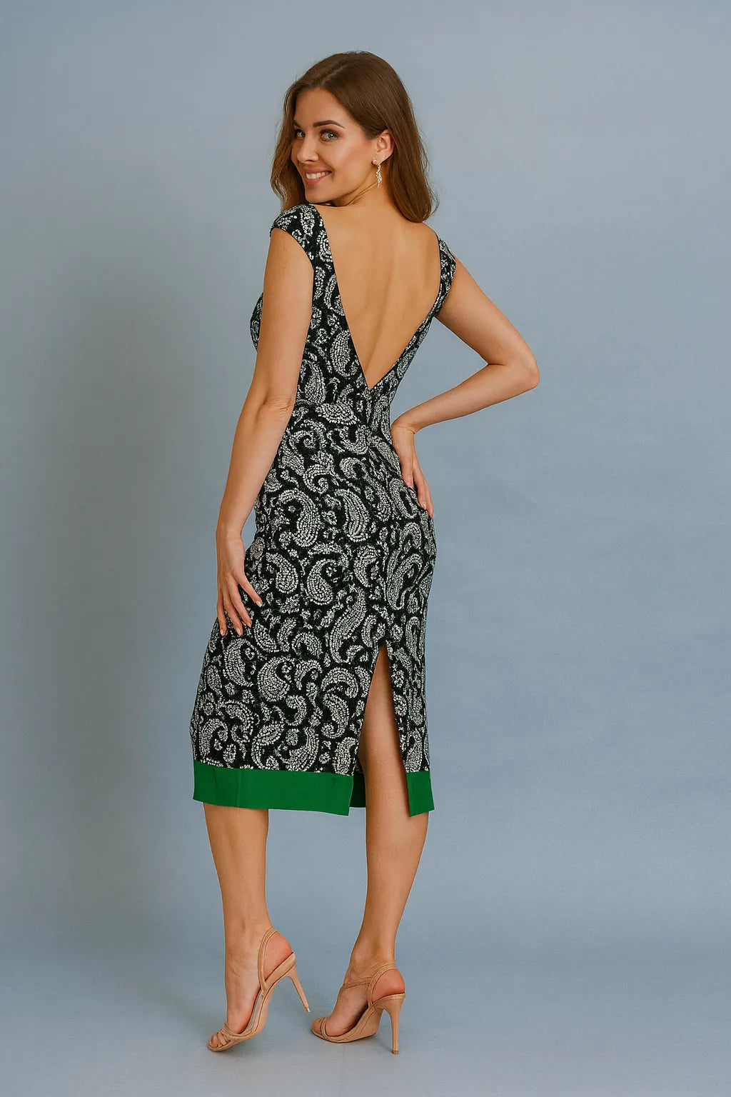 Woman wearing a patterned tango dress with a backless design on a gray background