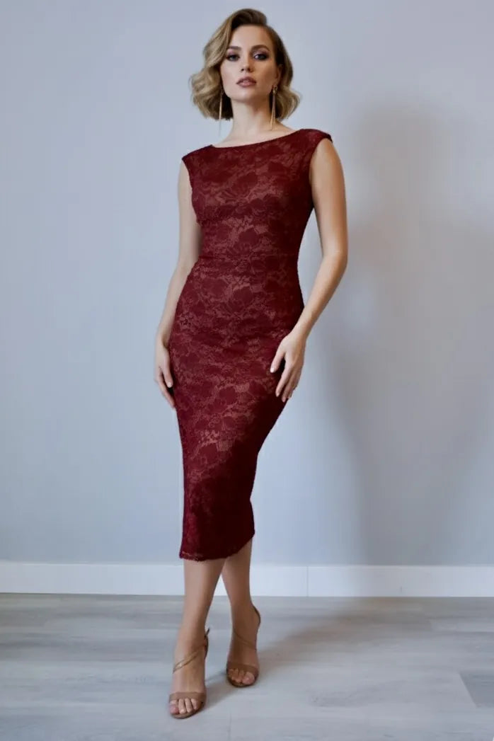 Woman wearing a burgundy tango lace dress against a plain background