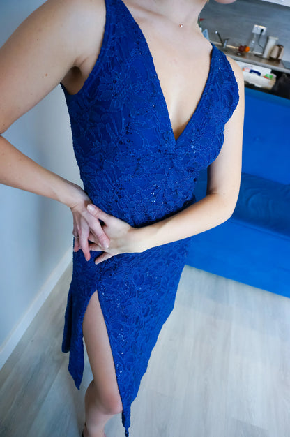 Person wearing a blue tango dress with a deep neckline and slit