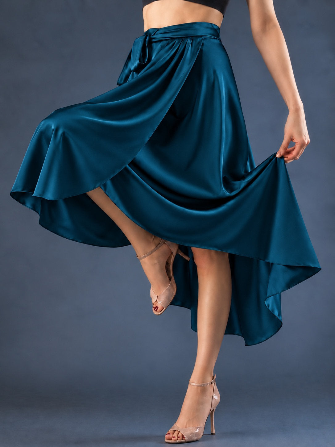 Front view of a women’s tango wrap skirt in flowing satin with a wide waistband, tie closure and asymmetric hem, designed for graceful movement in Argentine tango.