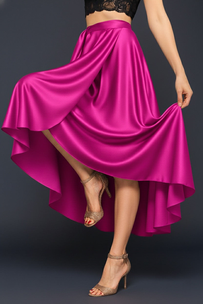 Person wearing a vibrant wrap pink tango skirt with a black top on a dark background