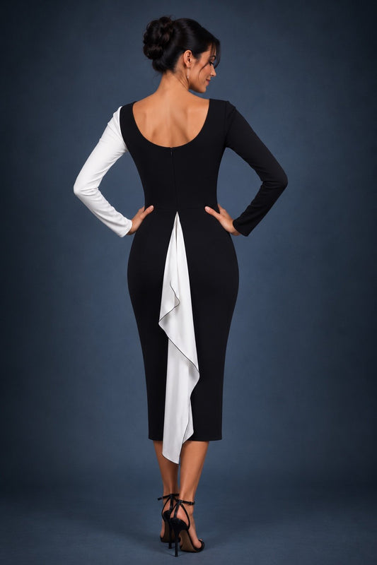 A woman wearing a long-sleeve colorblock pencil dress with a black and white split design, posed against a dark textured studio background.