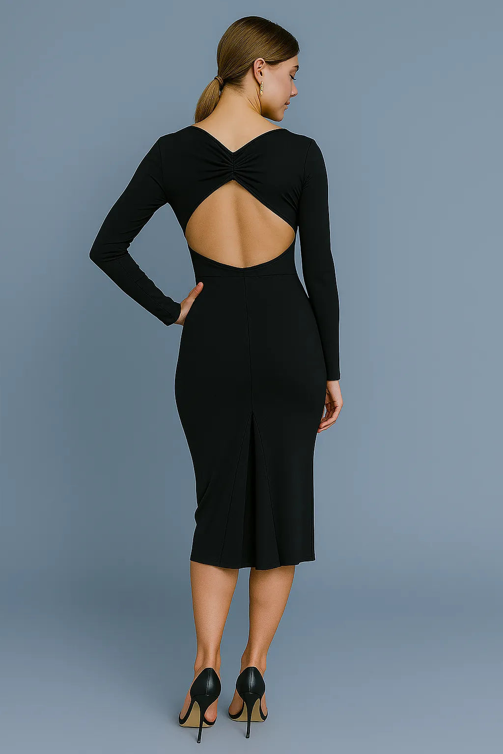 Woman wearing a black tango dress with an open back against a gray background