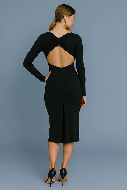 Woman wearing a black tango dress with an open back against a gray background