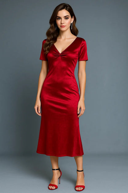 Woman wearing a red tango dress with a bow detail on a gray background