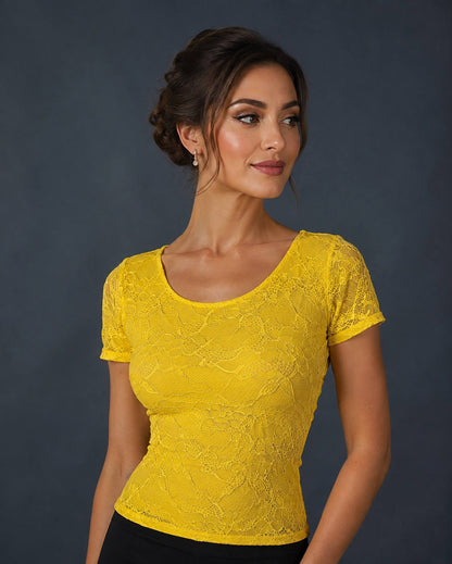 A woman wearing a bright yellow short-sleeve lace top.
