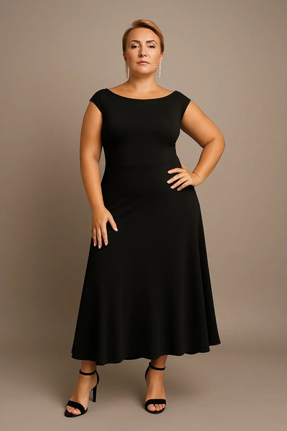 Woman wearing a black tango dress against a beige background