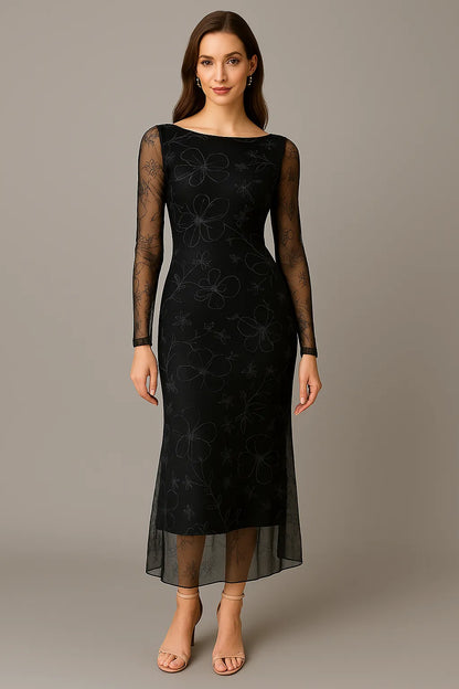 Woman wearing a black tango dress with sheer sleeves against a gray background