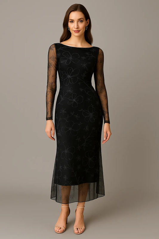 Woman wearing a black tango dress with sheer sleeves against a gray background