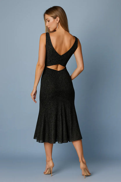 Woman wearing a black tango dress with cut-out design on a gray background