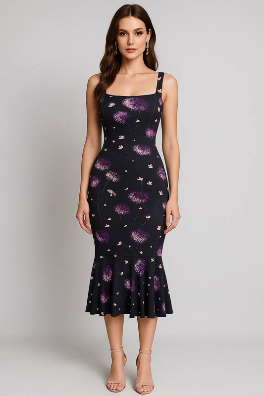 Woman wearing a black tango dress with purple floral pattern on a plain background