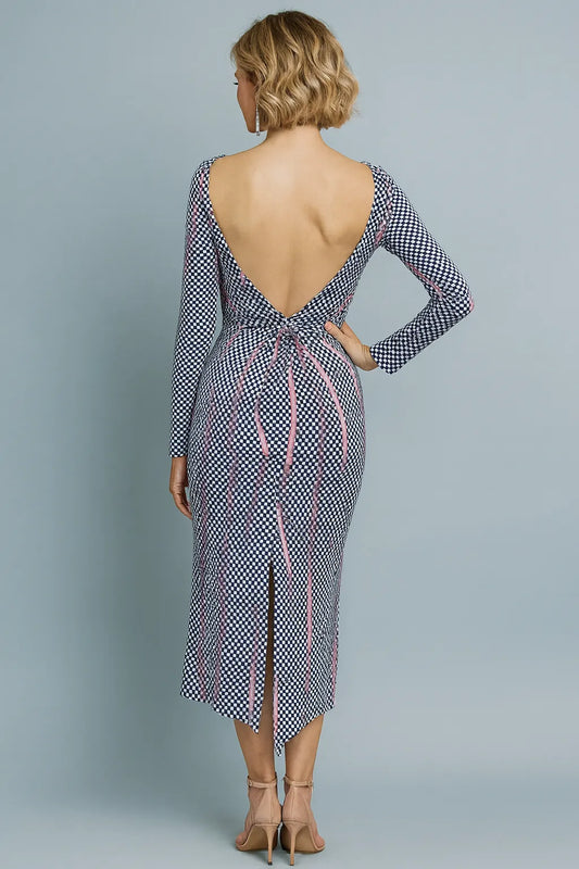 Woman wearing a patterned tango dress with long sleeves and open back on a gray background