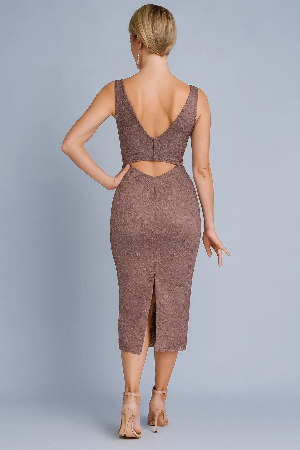 Woman wearing a brown tango dress with cut-out back on a gray background
