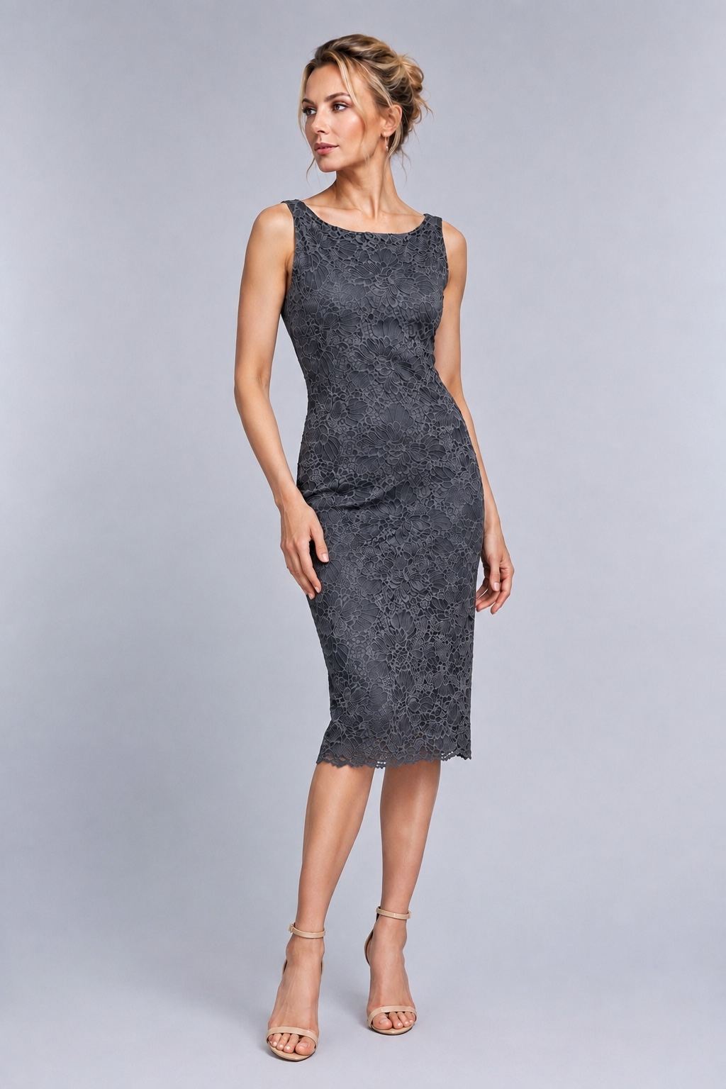 A woman modeling a sleeveless, knee-length dark gray lace dress against a light gray studio background.