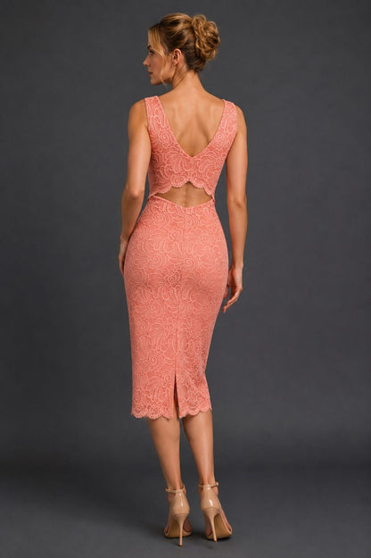 A woman modeling a peach lace midi dress from the back, showing a deep V-back and cutout waist, against a dark gray studio background.