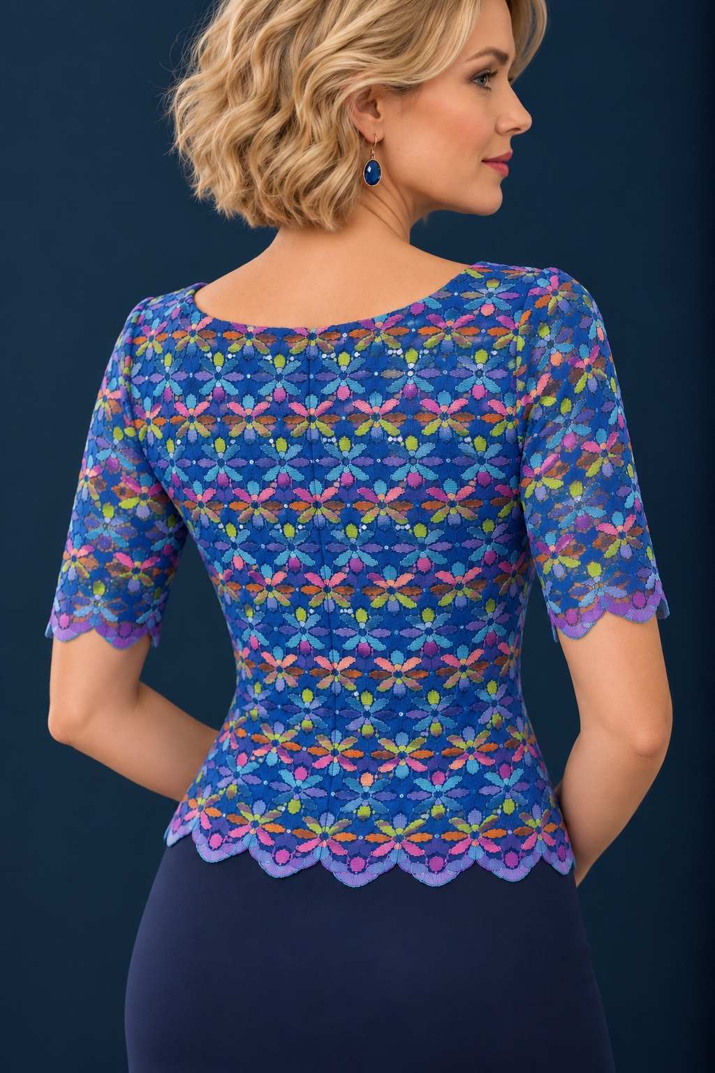 Back view of a women’s shimmering multicolour lace tango top with short semi-sheer sleeves, scalloped edges and a fitted silhouette.