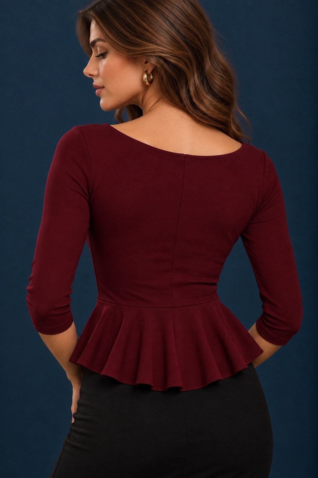 Back view of a rich burgundy jersey tango top with three-quarter sleeves, fitted bodice and flowing peplum waist.