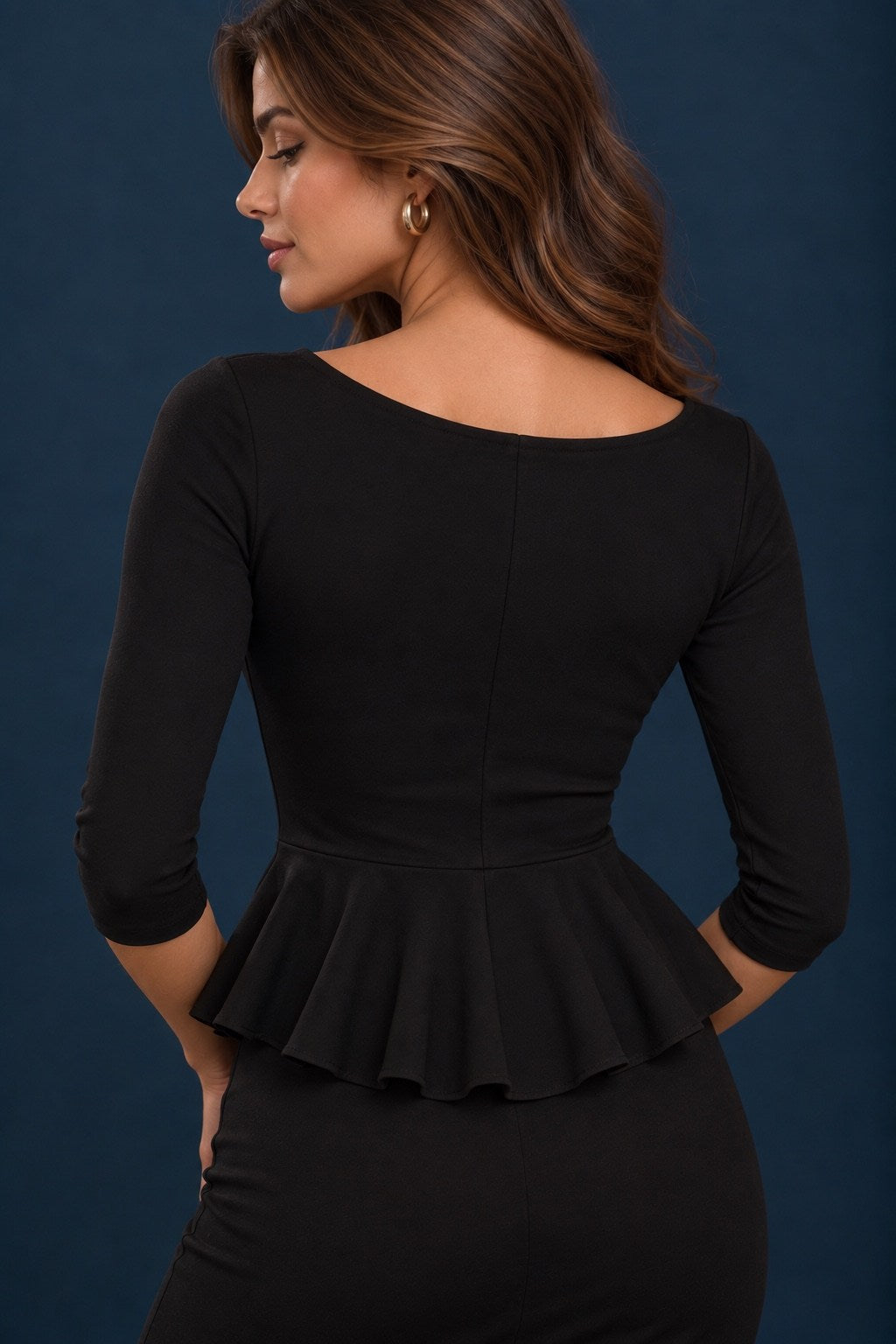 Back view of a black jersey tango top with three-quarter sleeves, fitted bodice and flowing peplum waist.