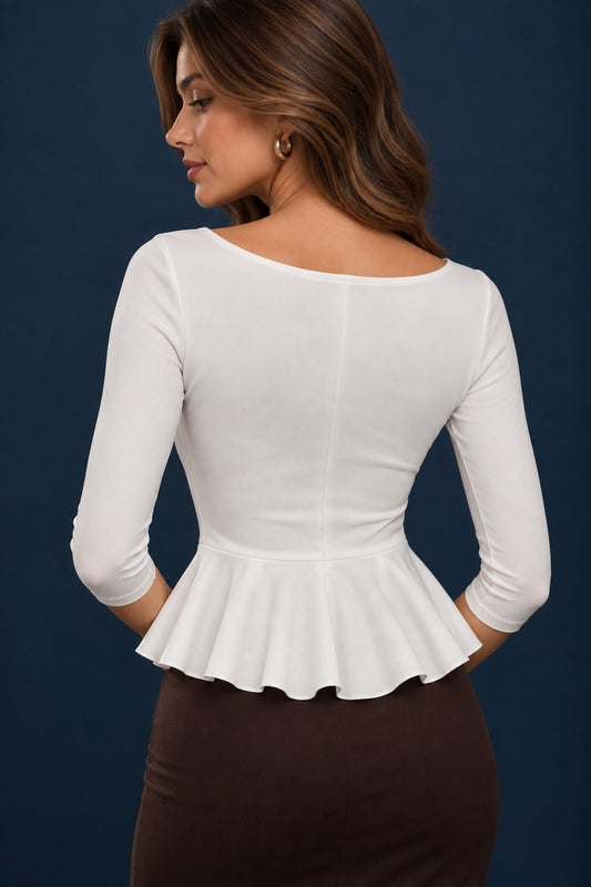 Back view of a milky white jersey tango top with three-quarter sleeves, fitted bodice and flowing peplum waist.
