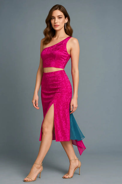 Woman wearing a bright pink one-shoulder tango top and pink tango skirt with a slit on a gray background