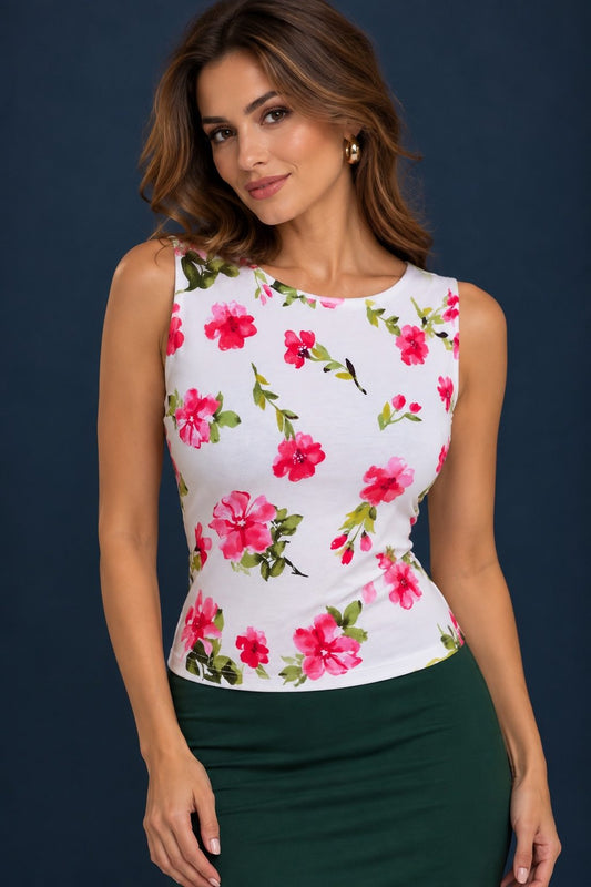 Woman wearing a white floral viscose tango top with pink flowers, sleeveless fitted silhouette and rounded neckline, front view.