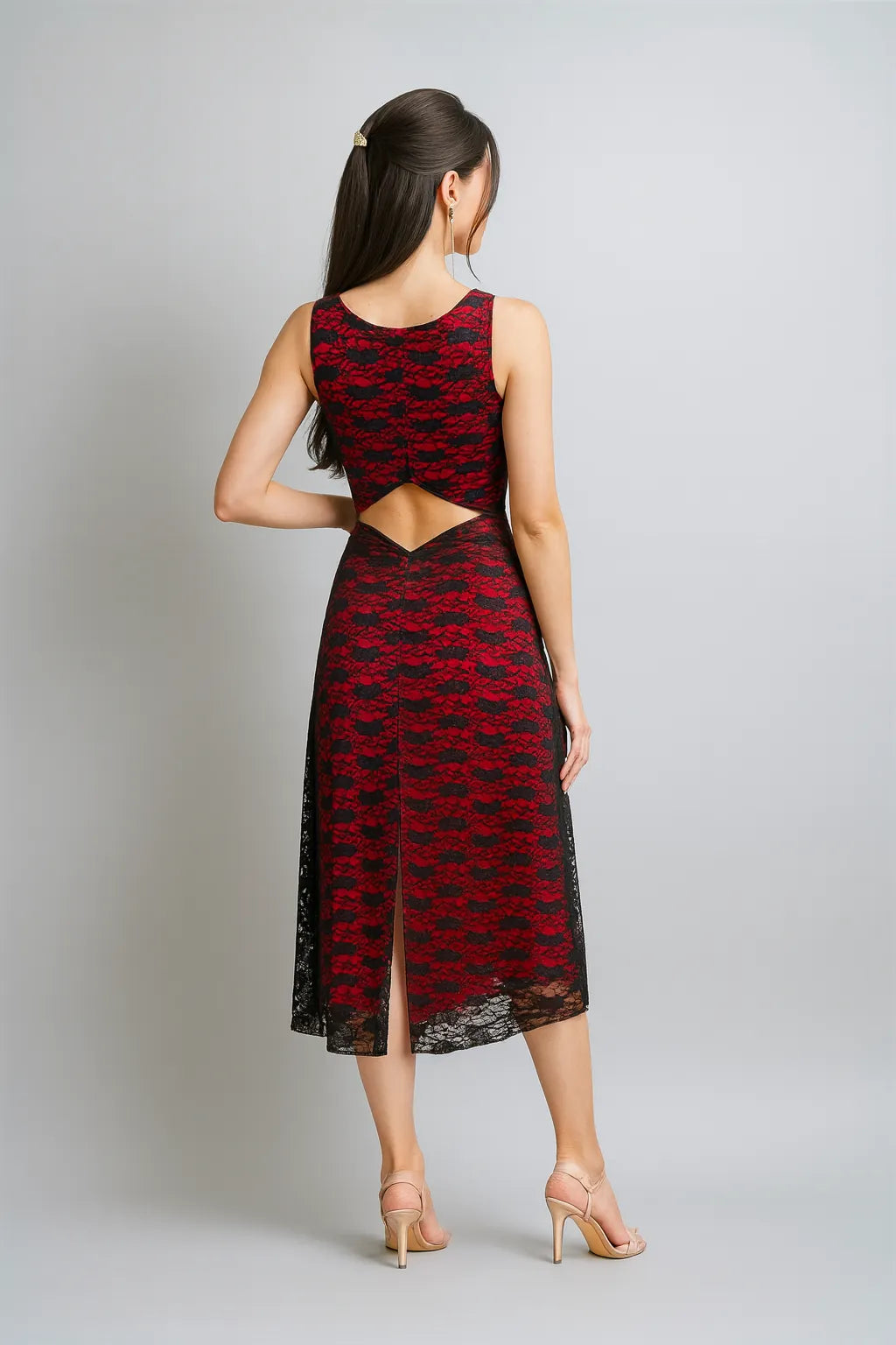 Woman wearing a red and black patterned tango dress with cut-out design on a gray background