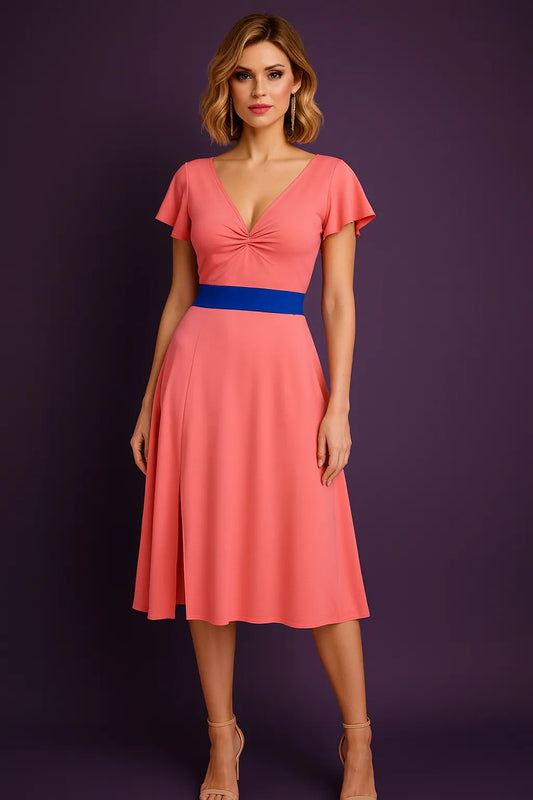 Woman wearing a pink tango dress with a blue belt against a purple background