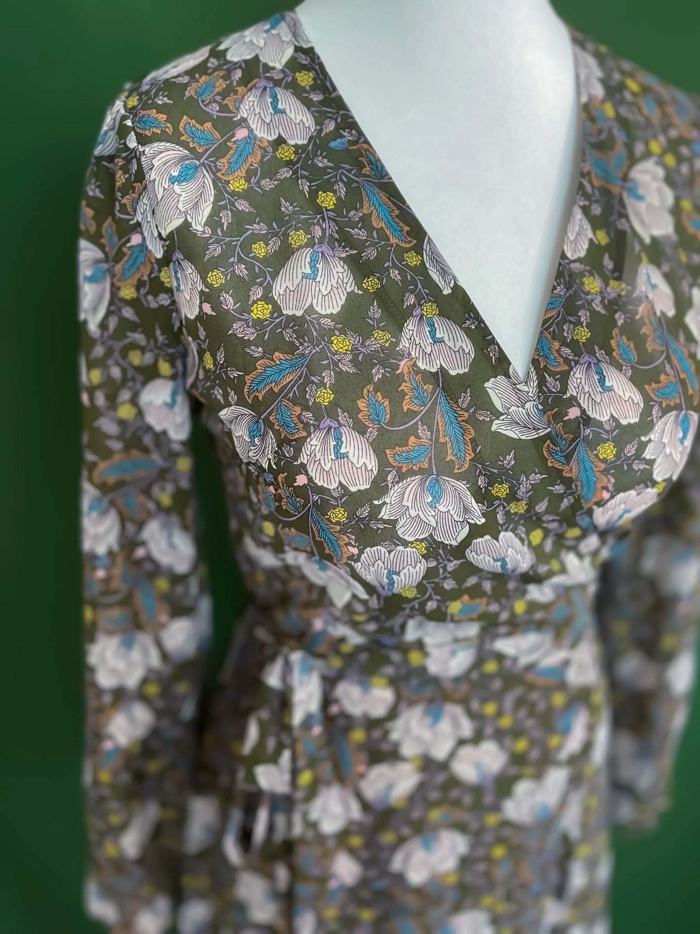 Feminine green wrap dress with flowing skirt and romantic details