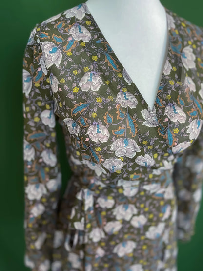 Feminine green wrap dress with flowing skirt and romantic details