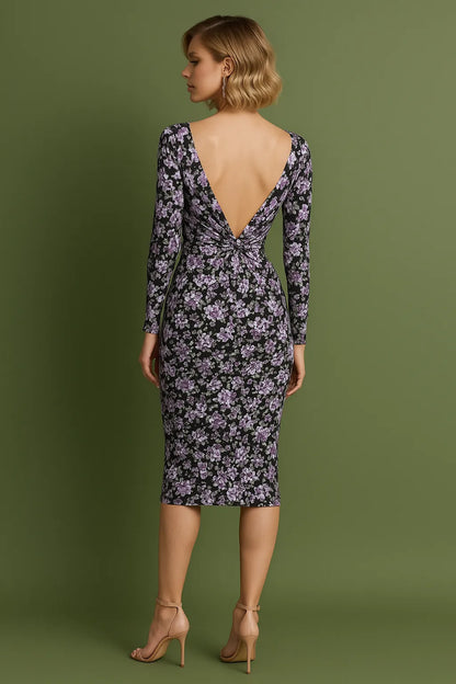 Woman wearing a floral tango dress with a deep backless design on a green background