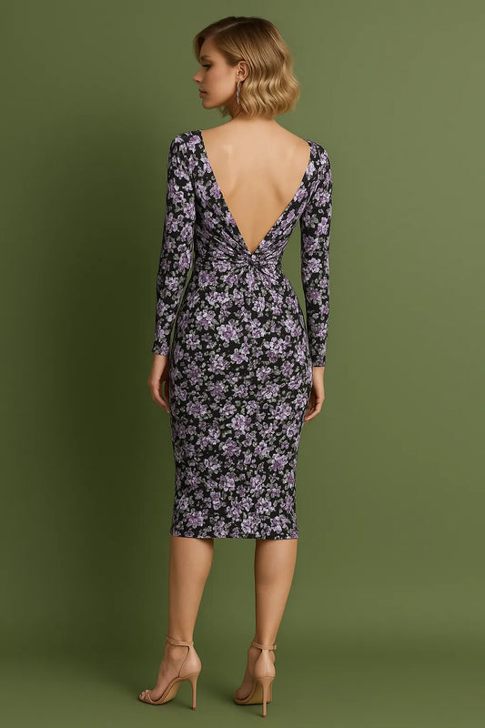Woman wearing a floral tango dress with a deep backless design on a green background