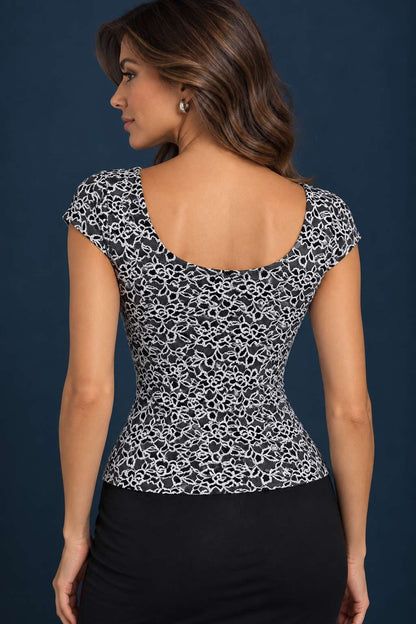 Back view of a black and white floral lace tango top with cap sleeves and a semi-open rounded back.