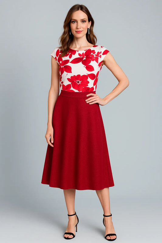 Woman wearing a red and white floral tango top with a red tango skirt on a gray background