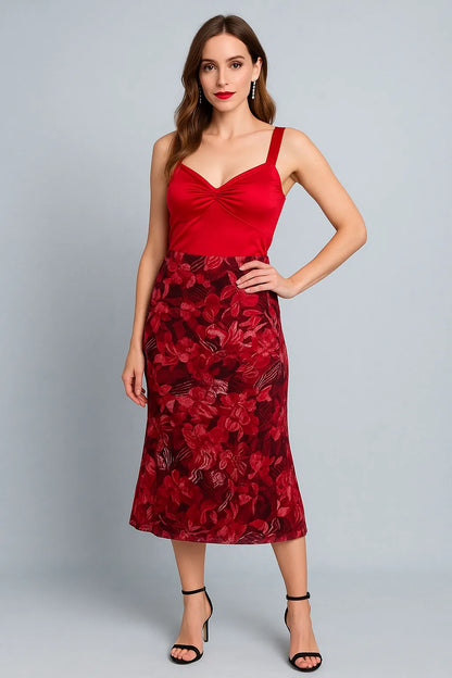 Woman wearing a red tango top with floral red tango skirt on a gray background