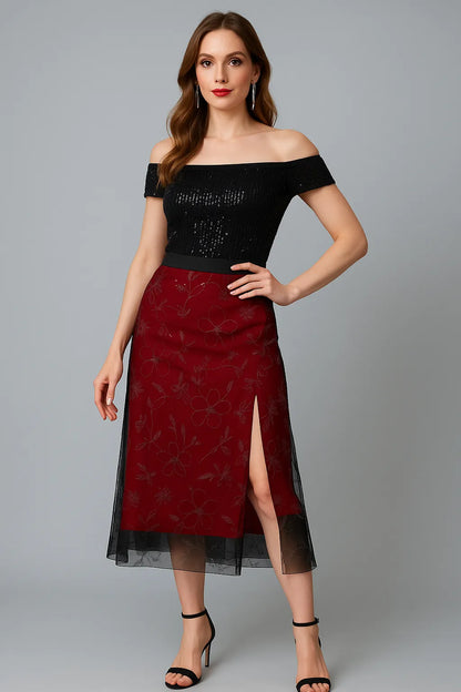 Woman wearing a black tango top and red tango skirt with a gray background