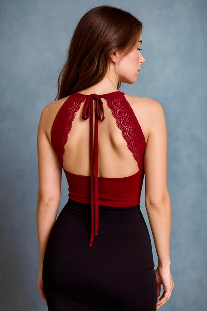Woman wearing a burgundy lace halter tango top with a black skirt.