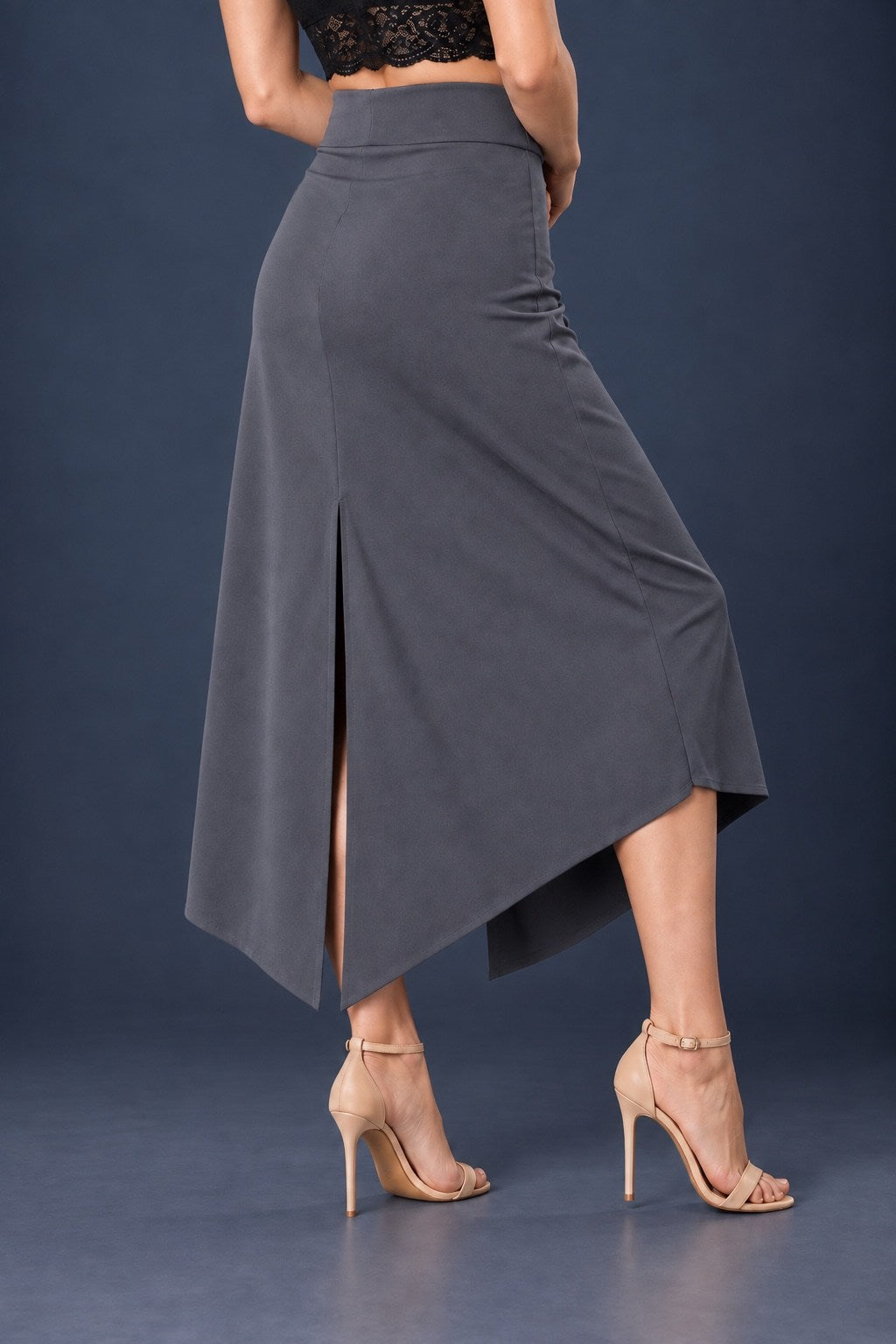 Back view of grey asymmetric jersey tango skirt with wide waistband, back slit and angled hem.