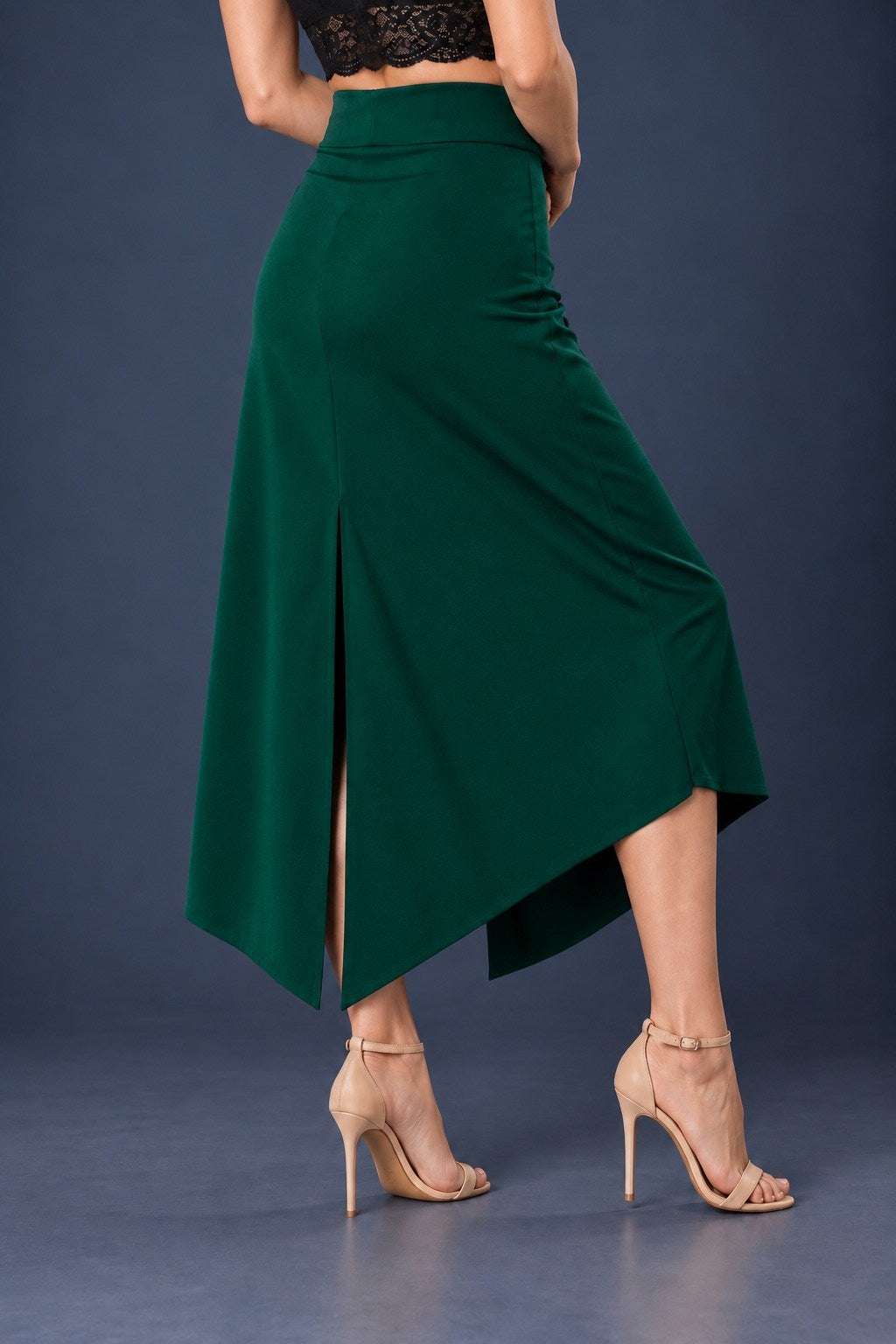 Back view of green asymmetric jersey tango skirt with wide waistband, back slit and angled hem.