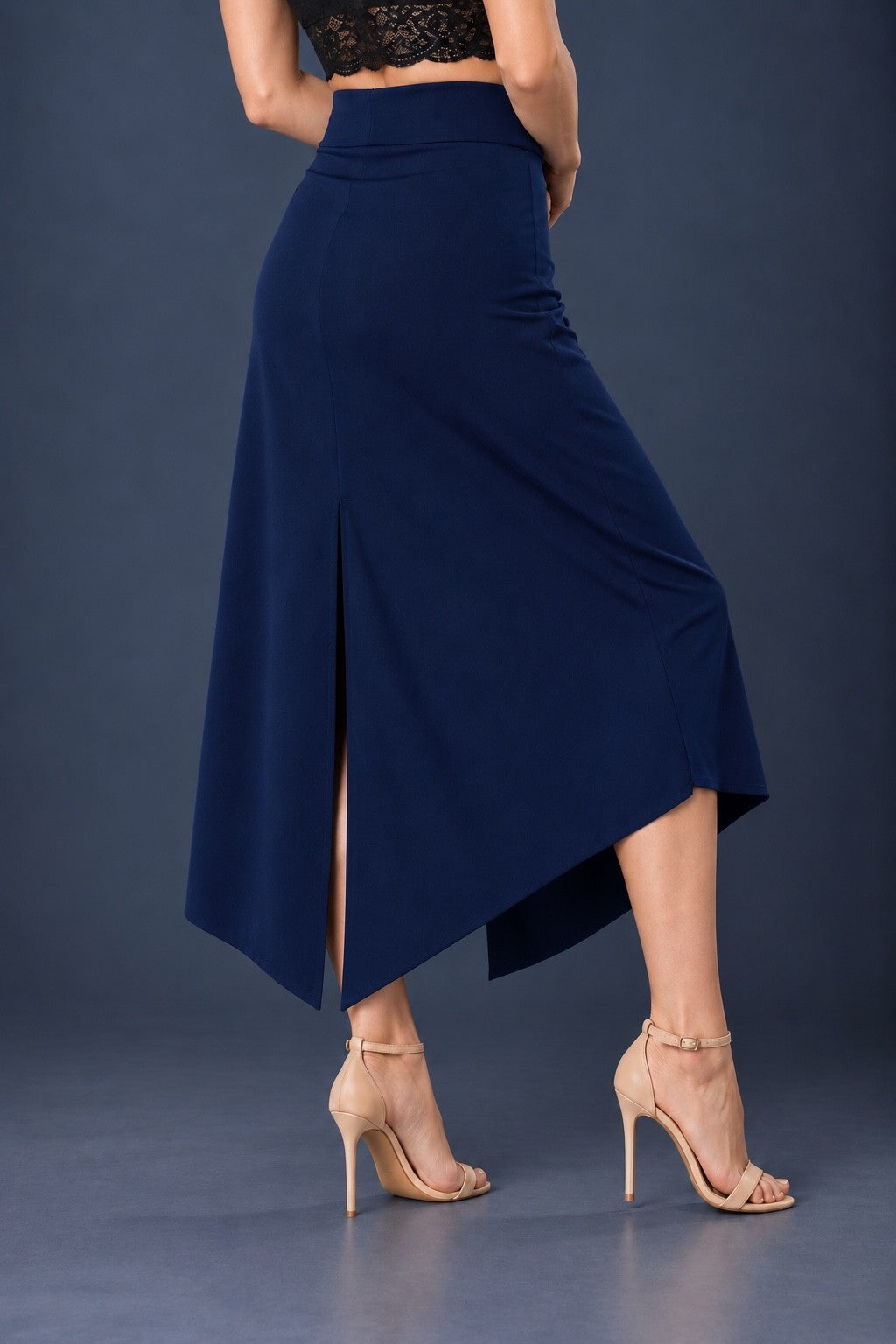 Back view of blue asymmetric jersey tango skirt with wide waistband, back slit and angled hem.