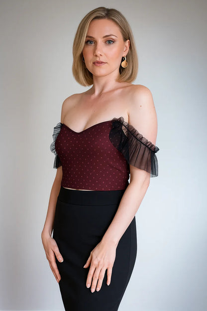 Woman wearing a burgundy tango top with sheer sleeves