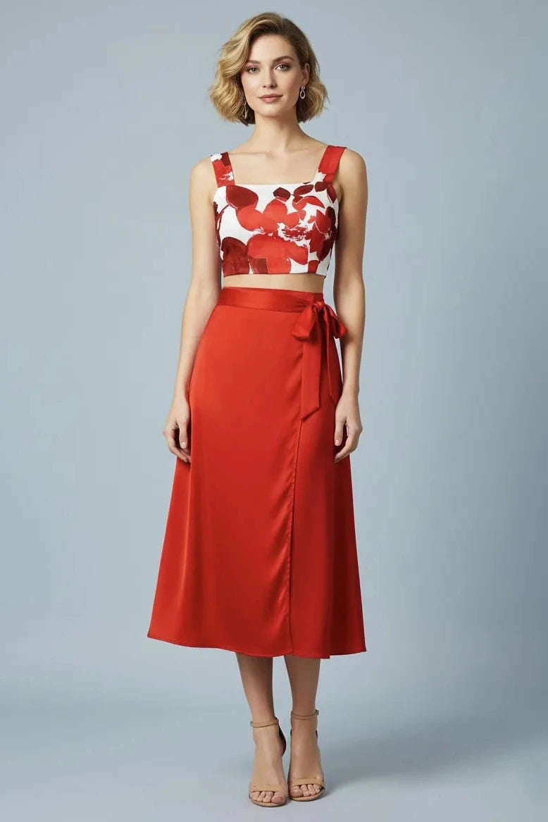 Woman wearing a red floral tango top and red tango skirt on a gray background
