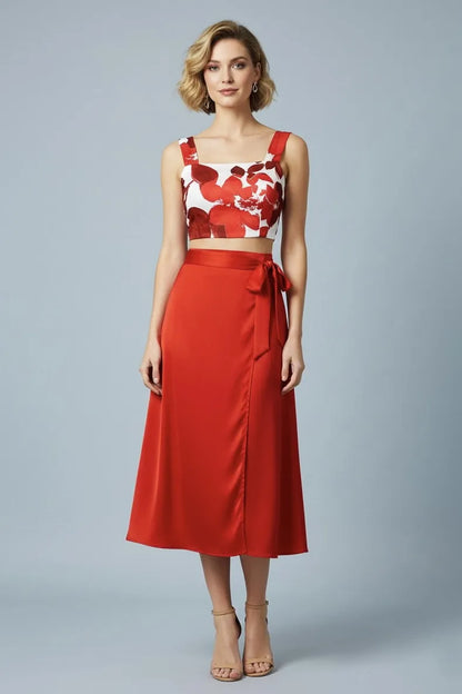 Woman wearing a red floral tango top and red tango skirt on a gray background