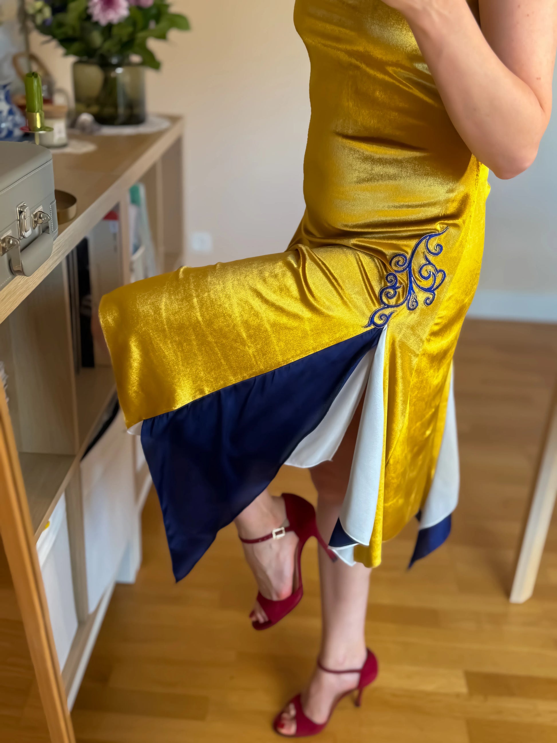Woman wearing a golden velvet tango dress with blue elements