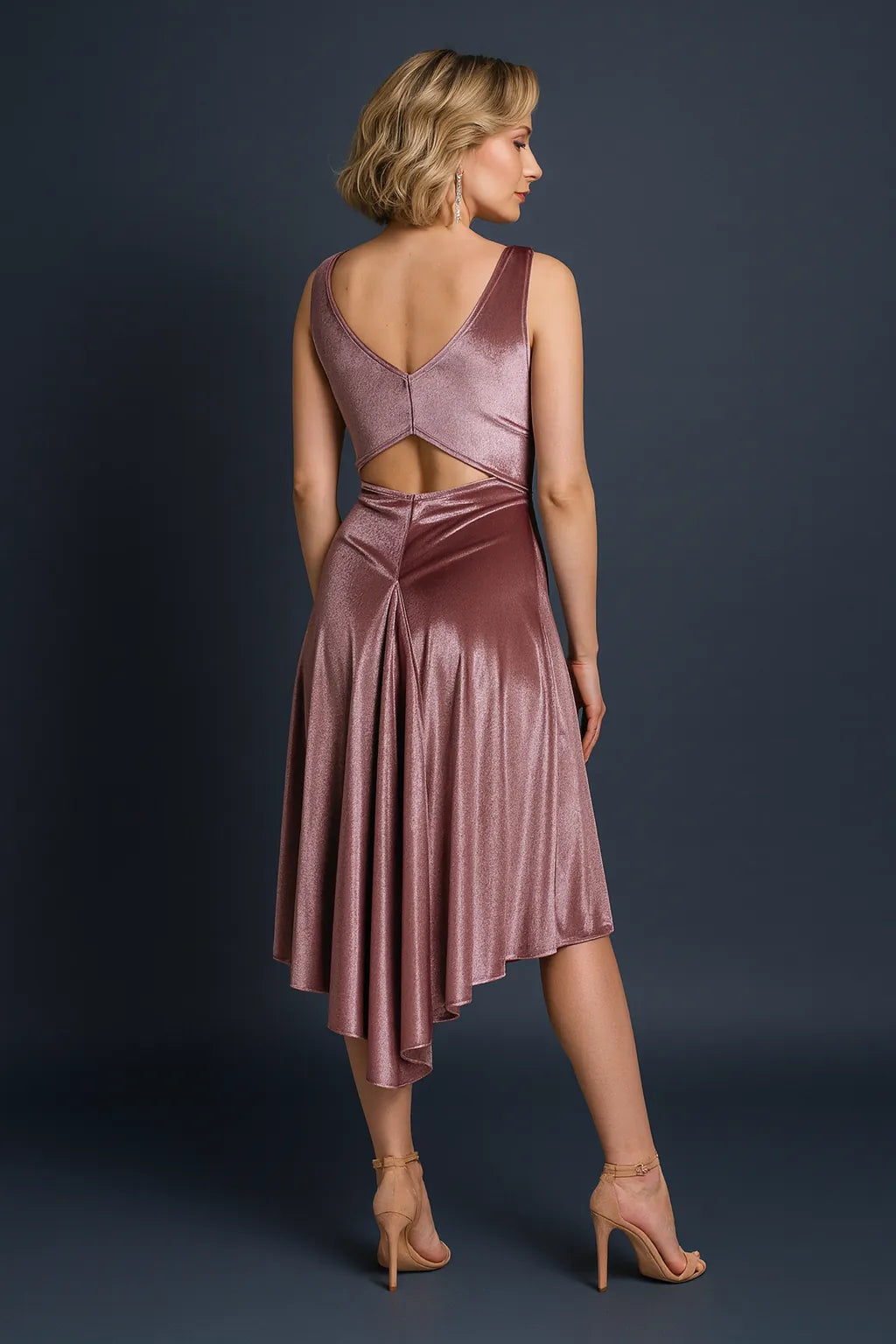 Woman wearing a dusty rose tango dress with cut-out design on a dark background, back view