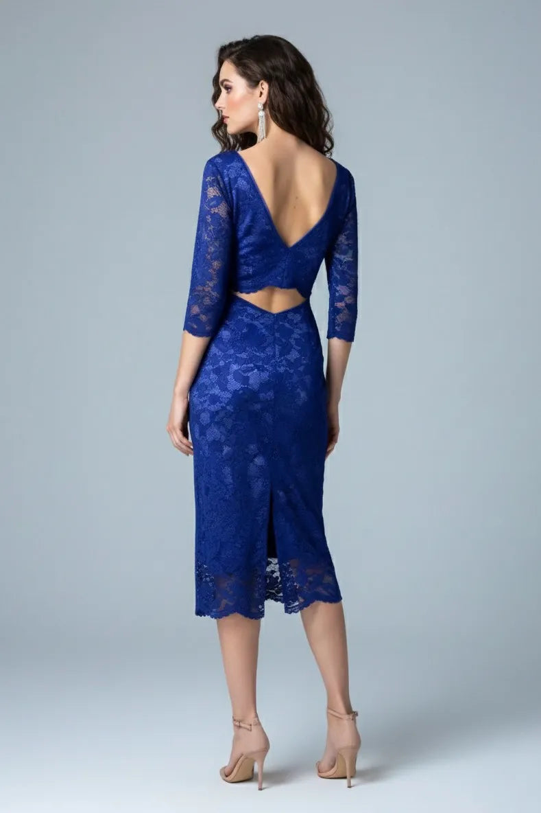 Woman wearing a blue lace tango dress with a plain background, back view.
