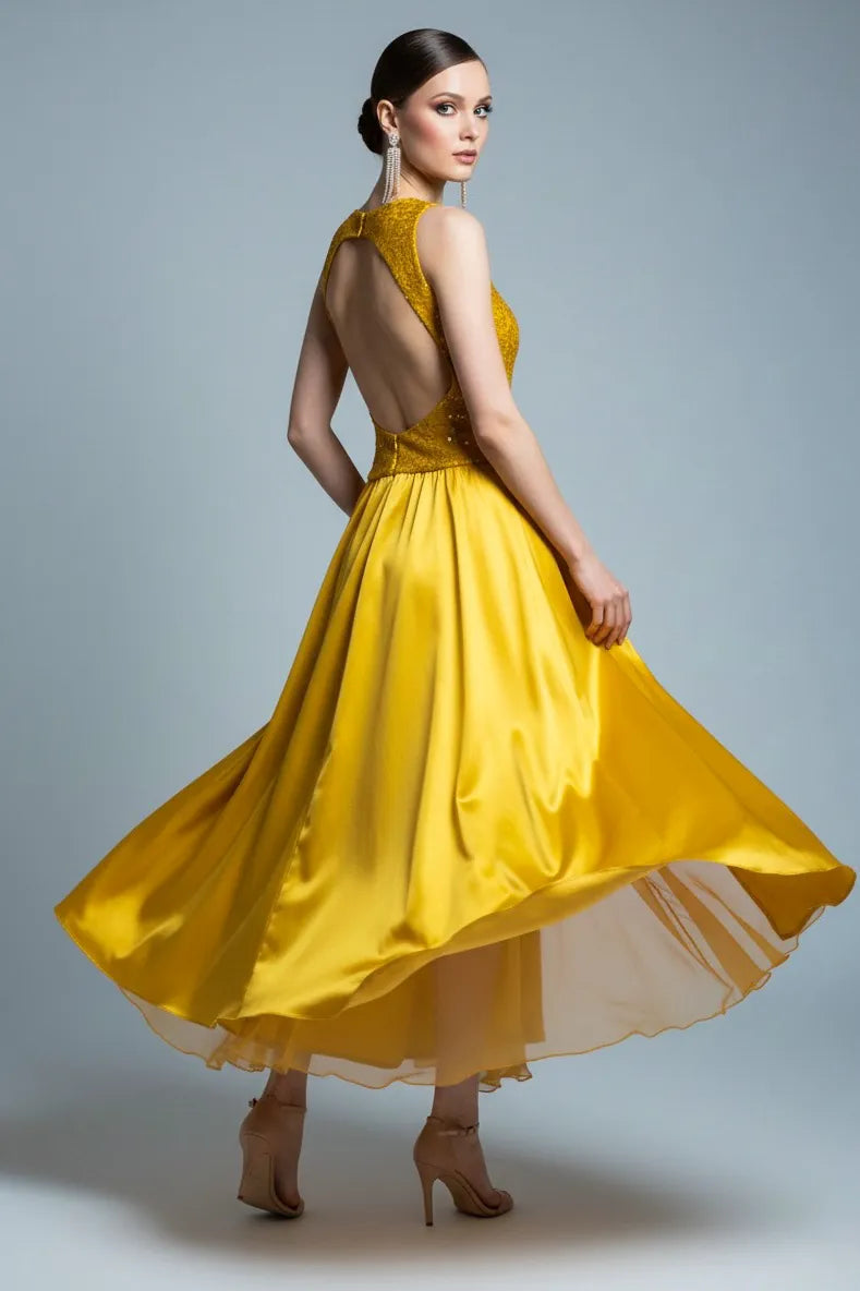 Woman wearing a golden tango dress with an open back on a gray background