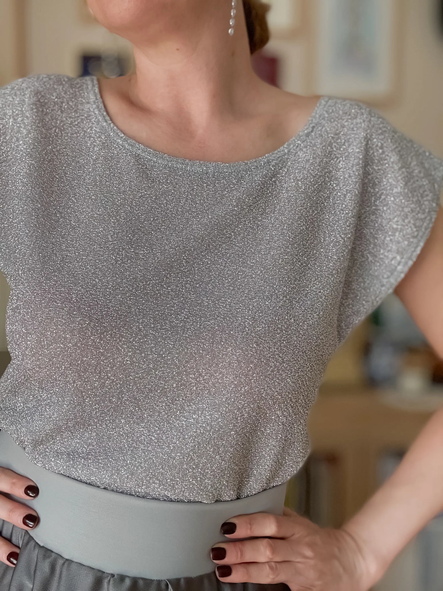 Woman wearing a silver shimmer tango top and grey skirt