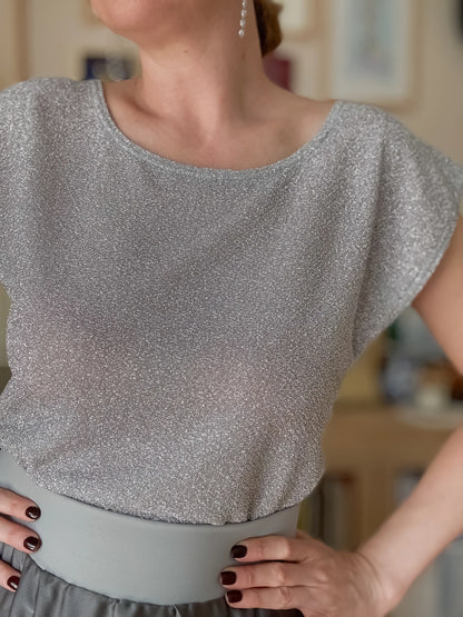 Woman wearing a silver shimmer tango top and grey skirt
