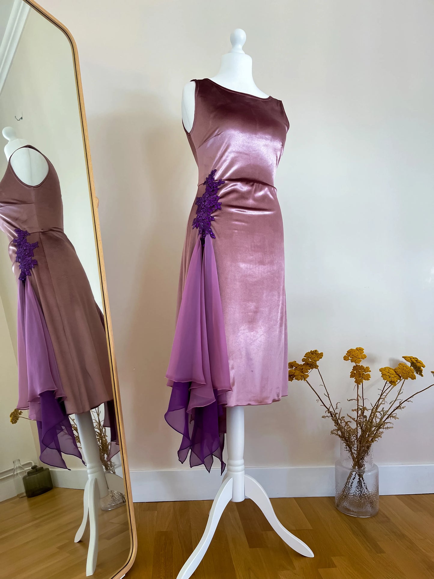 Purple and brown tango dress on a mannequin with a mirror reflection in a room.